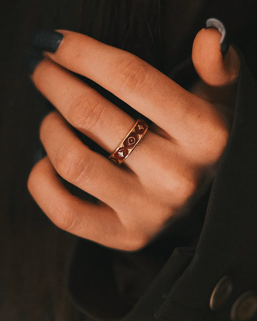 Burgundy Mosaic Band on the finger, a gold-tone band inlaid with burgundy enamel mosaic, dark sleeve